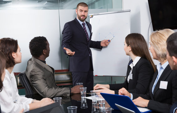 man giving presentation to colleagues at international business meeting