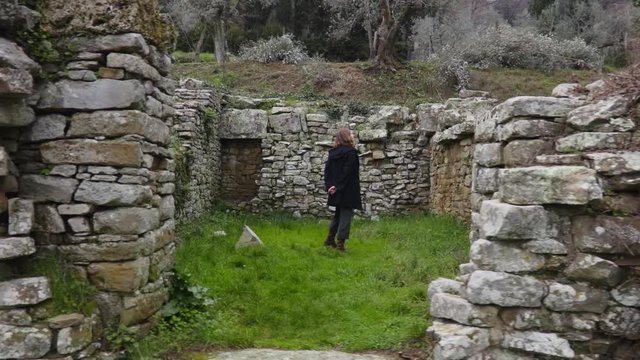 Woman looking an ancient ruins of the Italian town of Fiesole near Florence. Italian tourist attraction. Archaeological monument of Italy. Steadycam