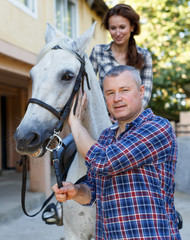 Man trainer teach to female while riding horse at ranch