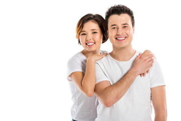 Fototapeta premium smiling portrait of young loving couple hugging and looking at camera isolated on white