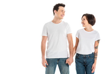 happy couple holding hands and looking at each other isolated on white
