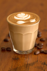 Coffee piccolo latte on wooden desk in coffe's shop