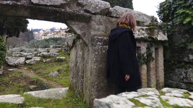 Woman looking an ancient ruins of the Italian town of Fiesole near Florence. Italian tourist attraction. Archaeological monument of Italy. Steadycam