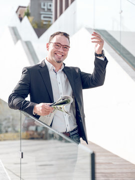 Thoughtful businessman with newspaper saying hello