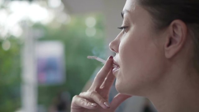 Closeup of woman smoking a cigarette outdoors close up