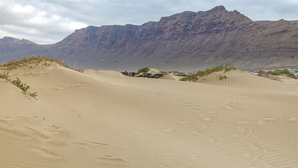 Sandverwehungen am Strand von Famara auf Lanzarote