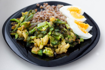 black plate with buckwheat broccoli and eggs