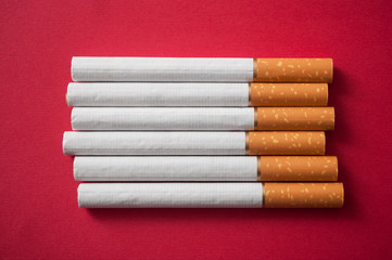 closeup of cigarettes alignment on red background
