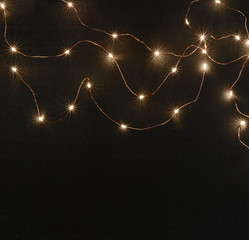Dark magic background card for Christmas or New Year. Bright blurry lights of a garland. Place for...