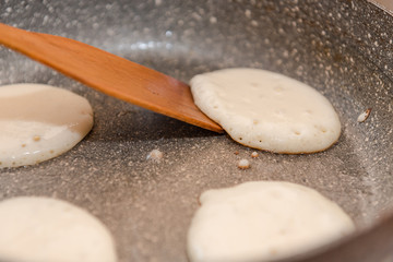 Fry fritters at home in the pan. Cooking pastries. Stand near the stove. View from above.