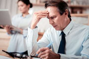 Smart thoughtful man touching his forehead
