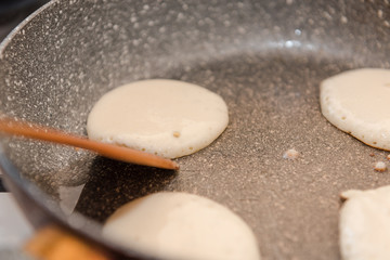 Fry fritters at home in the pan. Cooking pastries. Stand near the stove. View from above.