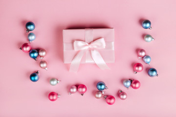 Christmas border with gift boxes, balls, decoration and sequins on pink table top view. Flat lay. Copy space for greeting card