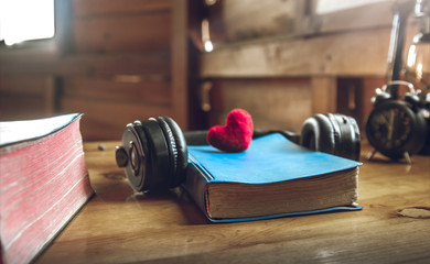 Bible with a red heart and earphone on wooden table. concept for obedience of God.