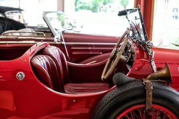 Roter Oldtimer-Cabrio mit roten Ledersitzen, Ersatzrad und Hupe an der Seite