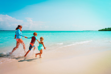 Fototapeta na wymiar mother with kids play with water run on beach