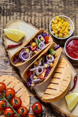 Fototapeta na wymiar Mexican food tacos, with chicken, pepper, tomato, avocado, corn in tortilla cake on wooden Board