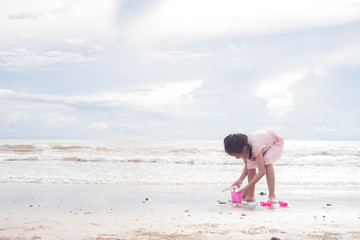 Fototapeta na wymiar Asian child girl playing with toys on the beach