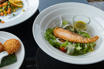 Grilled salmon on top of fresh salad, Concept of healthy food. Salad with green leaves and boiled salmon. Food photography. Fresh foods