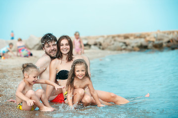 Fototapeta na wymiar Happy family enjoying walk on the sea beach. The summer, childhood, holiday, leisure, lifestyle, travel, vacation concept