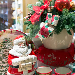 Santa Claus figurine with a list of desires on the background of Christmas decorations