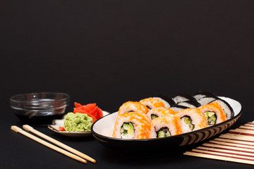 Uramaki California. Sushi rolls and plate with red pickled ginger and wasabi.