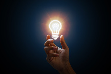 Business idea. Men hand holding light bulb