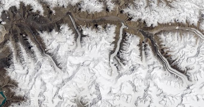 Vertical aerial ascent through light falling snow, over Karakoram mountains, Pakistan. Elements of this image furnished by NASA. 