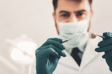 Close up of dentists hands with dental instrument