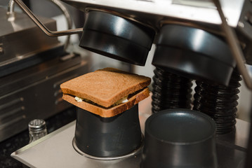 Cooking hot sandwich on special equipment in a restaurant or cafe. Fast food.