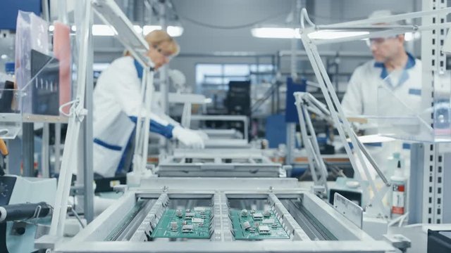 Time Lapse of Electronics Factory Workers Assembling Circuit Boards by Hand While it Moves on the Assembly Line. High Tech Factory Facility.
