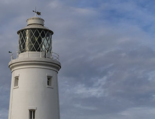 Nineteenth Century lighthouse, Victorian, built in 1890, with white painted brickwork. It's  glazed beacon, pictured against an Autumn sky. England.