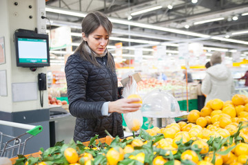 girl buying oranges and tangerines
