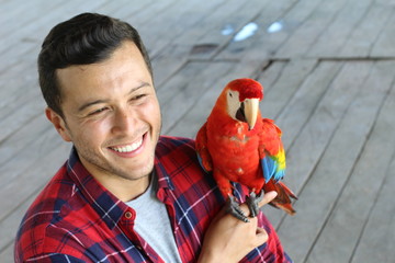 Fototapeta premium Ethnic man interacting with a gorgeous macaw bird