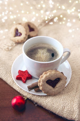 Christmas heart-shaped Cookie and coffee cup with red decoration.