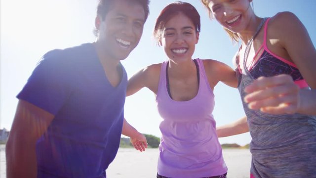 Smiling multi ethnic college friends having fun on their beach vacation