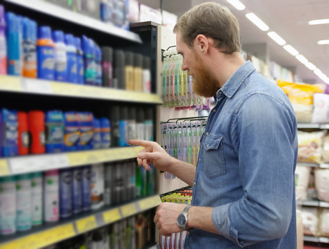 man choosing shaving products at   supermarket.