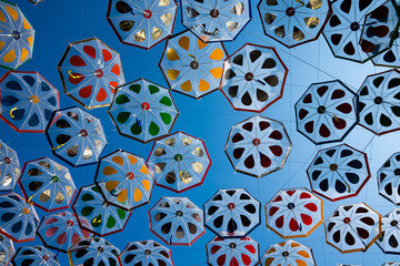 Many of the umbrellas against the blue sky.