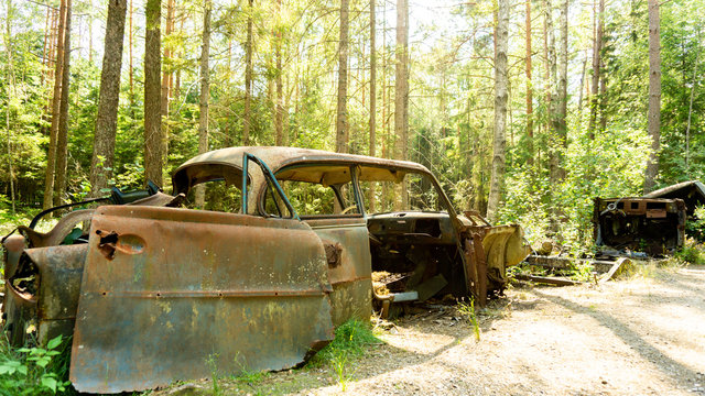 Altes rostiges Auto auf einem Autofriedhof im Wald