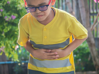 Cute little boy suffering from stomach ache. Health and injury concept.