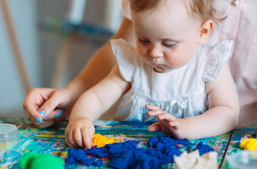 Mother and daughter playing with the kinetic sand.