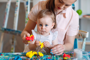 Mother and daughter playing with the kinetic sand.