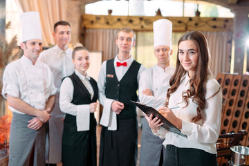restaurant manager and his staff in kitchen. interacting to head chef in commercial kitchen.