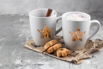 winter hot drinks with cookies in a shape of stars on a shabby concrete graybackground