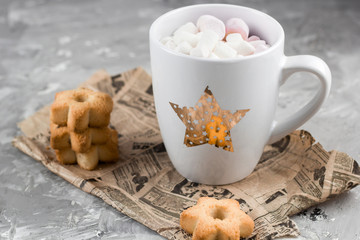 winter hot drinks with cookies in a shape of stars on a shabby concrete graybackground