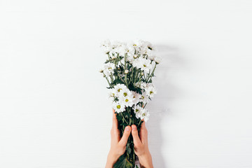Top view woman's hands holding bouquet of flowers