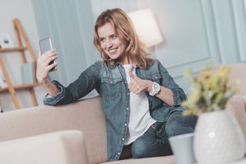 Delighted positive woman showing OK sign
