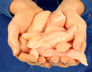 MAN HOLDING RAW CHICKEN FILLETS