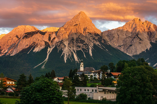 Berg bei Sonnenuntergang vor einem alpenl&auml;ndischen Dorf