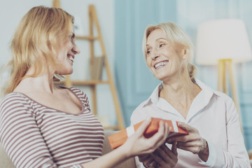Senior woman and her daughter standing with a gift